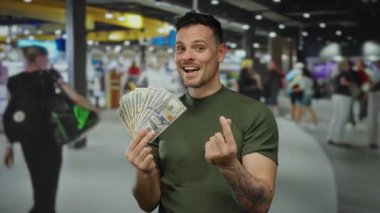 Havaalanı terminalindeki adam bize dolar tutarak kapalı alanda hareketli bir şekilde parmaklarıyla kalp hareketi yapıyor..
