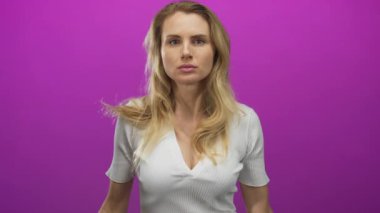 Kafkasyalı genç bir kadın, izolasyonda parlak pembe arka plana karşı el kol hareketi yaparak duygularını ve ifadesini canlı bir şekilde aktarıyor..
