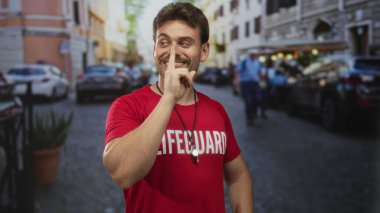 Kırmızı gömlekli adam cankurtaran, sessiz kalmak için parmaklar dudaklara park etmiş arabaları ve bulanık yayaları olan kalabalık bir caddede;.