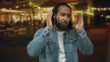 Meşgul bir şehir caddesinde, aydınlık kafeler ve gece lambasıyla el ele tutuşan adam, gürültülü ses sıkıntısı.