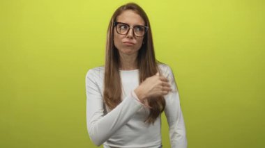 Çapraz kollu, büzüşmüş dudaklı ve gözlüklü genç İspanyol kadın limon yeşili bir stüdyodan etkilenmemiş gibi görünüyor..