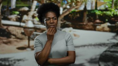 Şehir caddesinde doğa ile çevrili açık havada düşünen bir kadın aydınlık bir günde düşünce ve çeşitlilik sergiliyor..