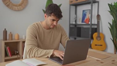 Adam dizüstü bilgisayarı açar ve evde yazmaya başlar. Bilgisayar aktiviteleri genç İspanyol erkekleri masa konsantrasyonuna çeker..