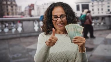 Uae 'deki orta yaşlı kadın Dirham Banknotları' nı tutuyor ve kalabalık bir şehir caddesinde onayı veriyor..