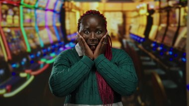 Kumar makineleriyle dolu renkli bir kumarhanede heyecanlı bir kadın. İçerideki eğlenceli ve heyecanlı atmosferi vurguluyor..