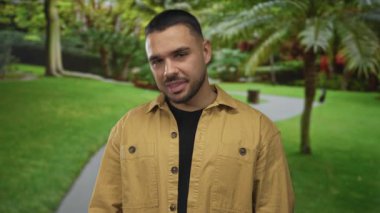 İnsan yeşil ormanda durur, yumuşak güneş ışığı altında kameraya bakarken geniş bir gülümsemeyle dişlerini gösterir. Mutluluk..