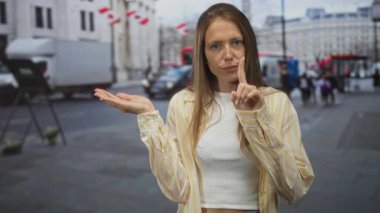Avuç içi açık bir şekilde işaret eden ve meşgul caddede işaret parmağı gösteren genç İspanyol kadın..