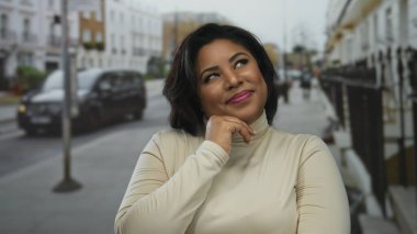 Şehir merkezindeki sokak ve arabaların arka planında gülümseyen bir kadın, kendinden emin bir İspanyol görünümünü sergiliyor..