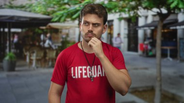 Kafe ve ağaçların yanındaki sokakta duran, düdük ve el çeneli cankurtaran, düşünceli ihtiyatlı bir görev..