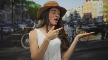 Hasır şapka takan ve beyaz atlet giyen kadın, güneş ışığı altında Kanal Köprüsü 'nde elleri ile 