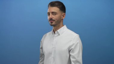 Beyaz gömlekli, ağzı açık, stüdyo portresi ayarlı canlı mavi arka planlı bir adam. Sürpriz..