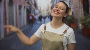 Sarışın kadın gülümsüyor ve ben kalabalık şehir caddesinde alnına jest yapıyor bulanık binalar; neşe.