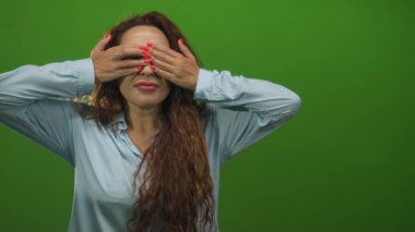 Gözleri mercan tırnaklarını gösteren ve stüdyo yeşiliyle gülümseyen bir kadın. Şaşırtıcı bir neşe kaynağı..