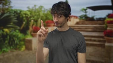 İnsan, taş merdivenlerin yanında saksı bitkileri olan merdivenler üzerine el ele barış işareti yapar; tasasız gevşeme.