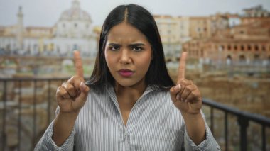 Bir kadın, Latin kökenli genç Latin asıllı Latin asıllı bir Latin 'in sokak harabelerinde sıkı bir jest yaparak ellerini kaldırdı..