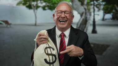 Takım elbiseli kıdemli bir adam elinde bir dolar işareti olan bir para çantası tutuyor, gülümsüyor ve sokakta iyi niyetini gösteriyor, başarı ve yozlaşma temalarını ima ediyor..