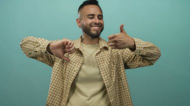 Stüdyoda parmaklarını öne eğmiş, tebessüm etmiş bir adam. Kararsızlık kararı..