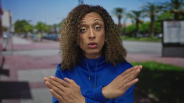 Kadın, şehir merkezindeki bir otobüs durağının yakınındaki güneşli bir caddede çıplak elle reddetme hareketi sergiliyor..