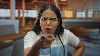 Lokantadaki çalışanları işaret eden bir kadın. Bu arada Latin asıllı genç müşteri içeride kızgın bir bakışla kahveyi tutuyor..