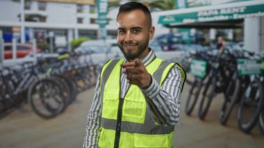 Yüksek görüşlü, elden ele gezen bisikletli bir adam bisiklet kiralama parkından çağrı için sokakta bekliyor..