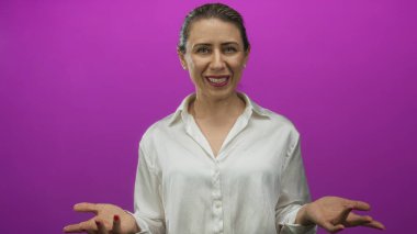 Stüdyo sahnesinde canlı mor arka plana karşı elleri açık sunan kadın, özgüven sıcaklığı.