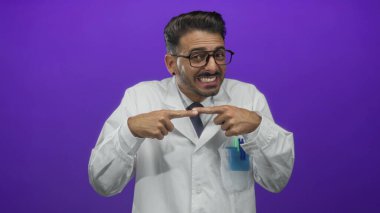 Beyaz önlüklü İspanyol bilim adamı, stüdyoda mor arkaplan ile omuz silkiyor; belirsizlik.