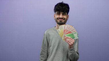 Elinde mor bir zemin üzerinde Norveç banknotları tutan genç bir adam, kendine güvenen bir ifadeyle sıradan bir ortamda krone para gösteriyor.