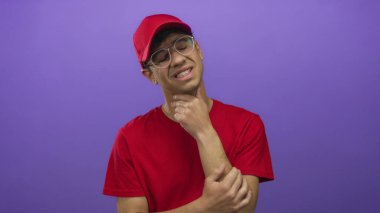 Mor stüdyoda boğazına dokunurken kırmızı gömlekli ve şapkalı genç teslimatçı yüzünü buruşturuyor..