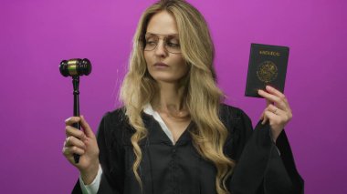 Woman judge in uniform holds mexico passport against pink wall, demonstrating authority and international travel context.