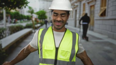 Yüksek görüş mesafesi olan yelek giyen ve başlık takan adam başını arkaya eğip şehir caddesinde gözlerini kapatıyor. Huzur..