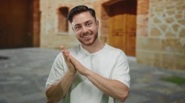 Sakallı genç adam, Stone Caddesi 'nin dışında, kırsal alanda, şehir atmosferini temsil eden arka plana gülümseyip ellerini sıkıyor..