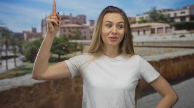 Güneşli gökyüzünün altında, arka planda fikir ve düşünceyi temsil eden tarihi binalar ve palmiye ağaçları olan eski bir şehir caddesini gösteren bir kadın..