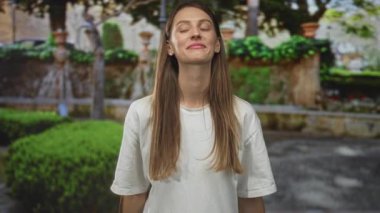 Avluda budanmış çalıları olan, elleri havada bir kadın, açık jest; sürpriz.