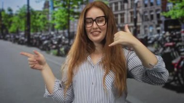 Yoğun şehir caddesinde bisiklet kuyruğunda işaret parmağıyla çağrı jesti yapan kadın, iletişim şakacı.