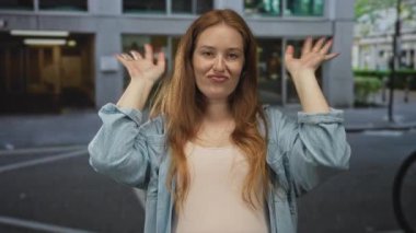 Genç kadın şehir merkezindeki modern ofis binasının önünde çapraz hareketler yaptı..