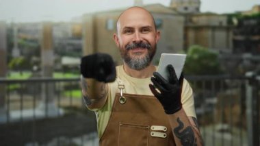 Antik Roma harabelerine karşı elinde defterle açık havada poz veren siyah eldiven ve önlük giyen bir adam, modern modayla tarihi mimarinin bir karışımını örnek gösteriyordu..