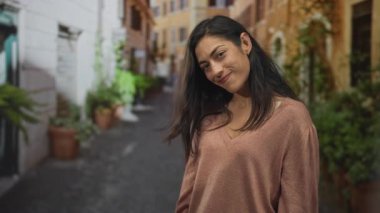 Kadın dar sokakta el sıkışmak için elini uzatıyor, gülümseyen yüz görünür ve öne uzanan el; dostça selamlaşma.