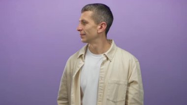 Gri saçlı, bej gömlekli beyaz bir adam mor bir duvara karşı şaşırmış ve izole ve anlamlı bir sahne yaratıyor..