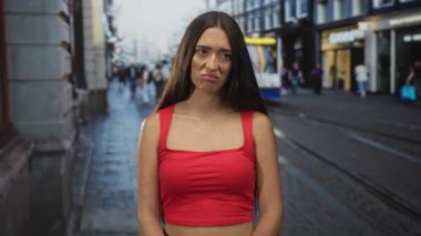 Şehrin işlek bir caddesinde çıplak köprücük kemiğini gösteren kırmızı bir tişört giyen bir kadın, şehir iğrenmesi..