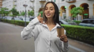 Beyaz gömlek giyen genç İspanyol kadın elinde kahve fincanı tutarken bana şehir caddesinde el hareketi yaptırıyor. Eğlenceli bir davet..