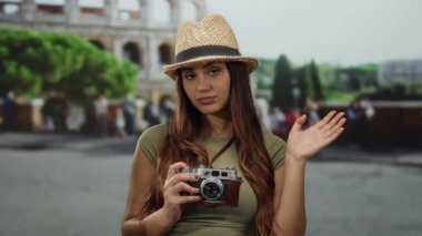 Roma Kolezyumu 'na el sallayan genç İspanyol kadın Roma, İtalya' da seyahat ve keşif sergiliyor. Turist olarak rolünü vurguluyor. Açık havada anılarını yakalıyor..