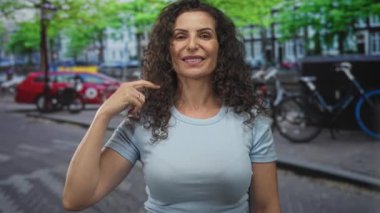 Yoğun şehir caddesinde bisiklet ve arabalarla göğüs göğse gezen açık mavi gömlekli bir kadın..