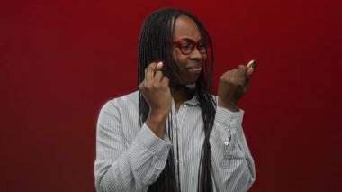 Kıvırcık saçlı kadın kripto para tutuyor parmakları kalın kırmızı bir duvara değmiş umut ve heyecan saçıyor..