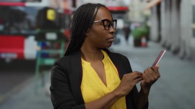 Otobüs durağında elinde Yunan pasaportu olan bir kadın şehir ortamında endişeli görünüyor..