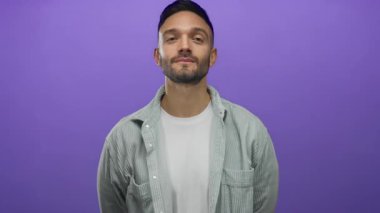 Kendine güvenen genç bir adam canlı mor bir arka plana karşı poz veriyor. Günlük beyaz gömlek ve çizgili ceket giyiyor. Modern tarz ve rahat tavır sergiliyor..