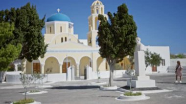 Santorini mavi kubbesi ve çan kulesi parlak güneş ışığı altında, yumuşak odaklı bokeh arka plan kilisesi; arka plan arka plan fotokopi alanı sakin.