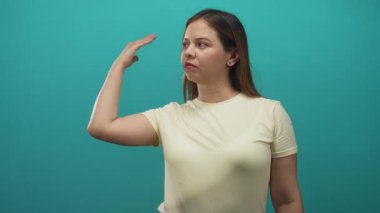 Avuç içini kaldıran ve soluk sarı tişört giyen bir kadın, hafif şüphecilik..