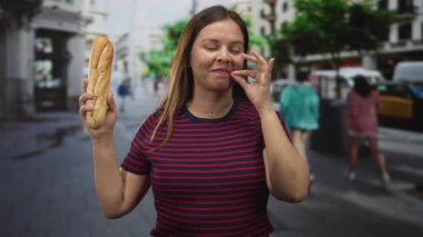 Baget tutan ve dağıtım kamyonları ve bulanık yayalarla dolu bir caddede elini sallayan genç bir kadın, eğlenceli bir eğlence..