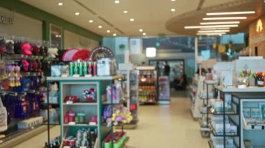 Perakende rafları boyunca yumuşak sığ bokeh ile bulanık dükkan içi ve odaksız koridor; arkaplan arka plan telif alanı.