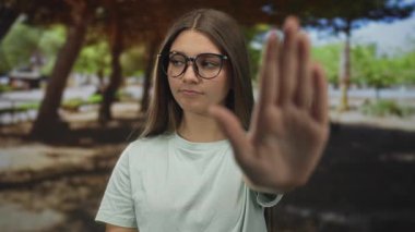 Kadın, yeşil parkta el ele tutuşup, doğal gün ışığı altında durarak kendine güveni artırıyor..